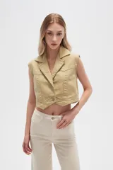 Chaleco cropped de jean color verde claro, con solapas y cierre frontal con botones.