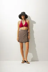 Minifalda marrón con rayas verticales negras y blancas, de corte cruzado con lazo lateral.