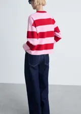 Sweater de punto fino con estampado de rayas horizontales en blanco y azul marino. Tiene cuello redondo, mangas largas y terminaciones en canalé.