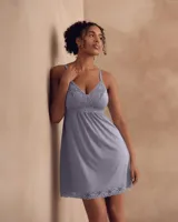 Chemise corta color lila con breteles finos regulables y apliques de encaje en el escote y el ruedo.