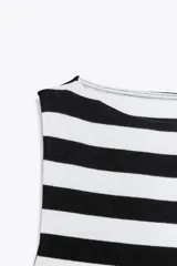 Camiseta sin mangas a rayas horizontales blancas y negras, con cuello barco y corte ajustado.
