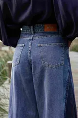 Pantalón de jean azul de corte ancho, con cintura alta y bolsillos delanteros y traseros.