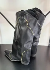 Botas texanas negras de caña alta con detalle de tachas doradas.