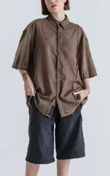 Camisa marrón de mangas cortas, corte holgado y cuello clásico.