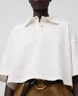 Polo corto de algodón orgánico color blanco, con cuello solapa y cierre de tres botones. Tiene mangas cortas japonesas y corte amplio.
