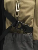 Mochila gris claro y gris oscuro con cordones elásticos cruzados en el frente y logo de la marca en la parte superior.