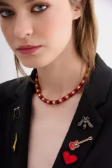 Gargantilla con cuentas rojas, negras y doradas.