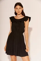 Vestido corto negro con escote redondo y volados en los hombros.