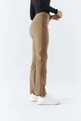 Pantalón de vestir color café con corte recto, tiro alto y elástico en la cintura. Presenta bolsillos laterales y detalle de cuero en los laterales.