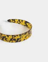 Vincha rígida con estampado carey en tonos amarillos y negros.