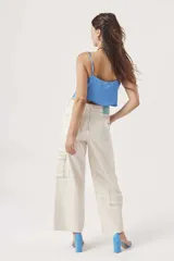 Blusa celeste de satén con breteles finos y escote drapeado.