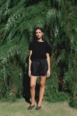 Short negro con bordado de flores rosas, con elástico en la cintura y cordón ajustable.