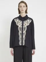 Camisa negra de corte amplio con botones en la parte delantera y aplique de macramé en el frente.