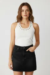 Musculosa blanca de algodón con cuello halter y detalle de ojales metálicos.