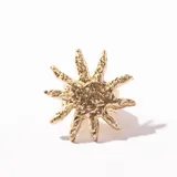 Anillo dorado con forma de estrella texturizada.
