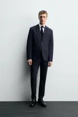 Blazer slim fit color verde oliva, confeccionada en tejido con viscosa. Tiene cuello con solapas de muesca, manga larga con puños abotonados, bolsillo de vivo en el pecho, bolsillos de solapa en la cadera, bolsillo interior, aberturas en la espalda y cierre frontal con botones.