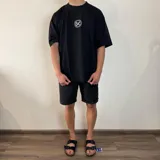 Remera negra de corte oversize y mangas cortas, con estampa en la espalda de una fotografía en blanco y negro de una persona fumando.