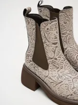 Botas Chelsea color beige con estampado floral, elástico lateral marrón y suela track color marrón.