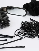 Set de accesorios para el pelo que incluye seis horquillas negras, un scrunchie negro, cincuenta gomitas de silicona negras y un cepillo negro.