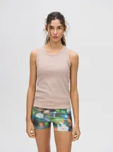 Musculosa crop de algodón color beige, con cuello redondo y puños acanalados. Presenta un pequeño logo bordado en el centro del pecho.