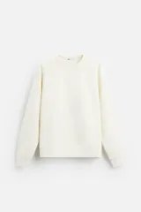 Sudadera color crudo, de corte relajado, con cuello redondo, mangas largas y terminaciones acanaladas.