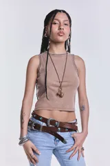 Musculosa corta color beige con cuello redondo y sisas con detalle de tachas plateadas.
