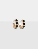 Aros tipo argolla dorados con flores esmaltadas negras.