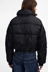 Campera puffer marrón de nylon, capitoneada y acolchada, con cuello alto, cierre frontal y cintura elastizada.