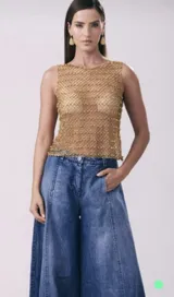 Musculosa dorada tejida a mano en red metálica.