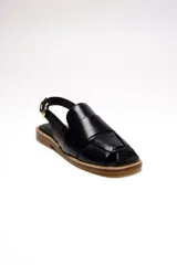 Sandalia negra de cuero con diseño tejido en el empeine, tira trasera con hebilla dorada ajustable y suela plana.
