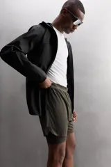 Shorts de running negros confeccionados en tejido técnico ligero y elástico, con malla interior, cintura elástica ajustable con cordón, bolsillo trasero con cierre y perforaciones en las perneras.