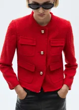Chaqueta roja de tweed con cuello redondo, cierre frontal con botones metálicos y cuatro bolsillos de parche.