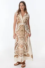 Vestido largo color crema con estampado cachemir en tonos marrones, con cuello camisero, sin mangas y abotonado al frente.