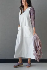 Vestido blanco de gabardina de algodón, corte evasé, sin mangas, con cuello redondo y bolsillo delantero.