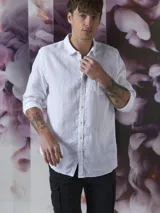 Camisa azul de lino con botones blancos, manga larga y bolsillo en el pecho.