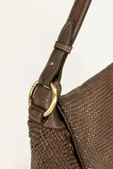 Cartera marrón de cuero tejido con solapa y correa de hombro ajustable.