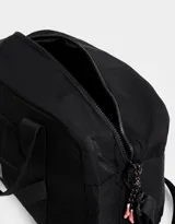 Bolso de tela deportiva color negro, con bolsillo frontal y doble asa corta de mano. Incluye correa regulable y desmontable, cierre superior con tirador de cordón y goma, y tag de goma.