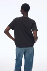 Remera negra de algodón, corte amplio, con cuello redondo y mangas cortas.