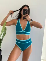 Conjunto de bikini verde con detalles en celeste. El corpiño es de corte triangular con tirantes finos y la bombacha es de tiro alto.