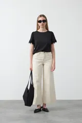 Remera negra de tejido acanalado con excelente elasticidad, corte al cuerpo y mangas cortas con terminación de puntilla.