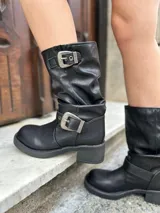 Bota corta negra de cuero con hebillas plateadas y taco bajo.
