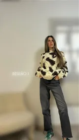 Sweater de lana merino con cuello redondo y diseño con motivos geométricos en tonos azul, marrón, naranja, verde y beige.