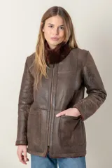 Campera de cuero marrón gastado, con cuello de piel sintética marrón y cierre frontal con cremallera.