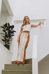 Falda larga color marrón con paneles verticales en tonos beige y blanco.