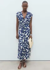 Vestido largo de manga corta con estampado de hojas en azul marino y blanco. Presenta escote de pico, fruncido ajustable en la cintura y corte evasé.