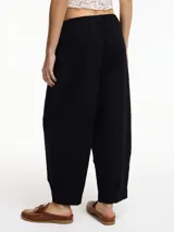 Pantalón tipo chino color crudo, con bolsillos laterales y pretina elástica. Textura arrugada.