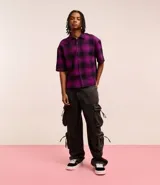 Pantalón de jean super baggy color gris oscuro, con trabillas en la cintura, bolsillos laterales tipo cargo y cierre tradicional.
