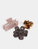 Set de tres broches para el pelo de diferentes formas y colores: uno con diseño carey, otro con forma de flor color marrón y otro rectangular color rosa.