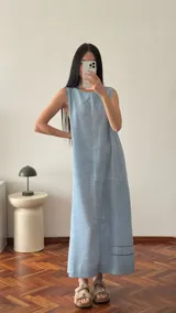 Vestido largo celeste de lino, corte recto y sin mangas, con dos líneas bordadas en el ruedo.