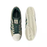 Championes Adidas Superstar color beige con detalles en verde oscuro y suela color crema.